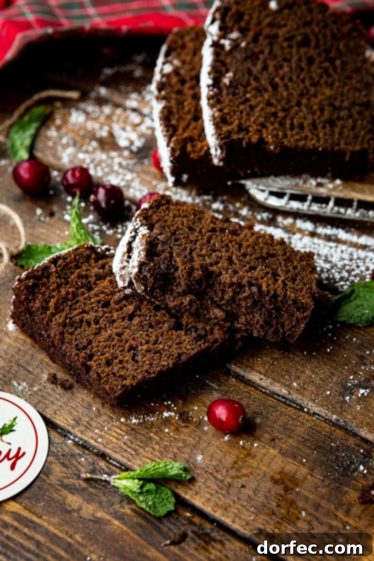 Classic Gingerbread Loaf 11 A beautiful photo featuring two enticing slices of gingerbread loaf resting on a rustic table, positioned in front of a full, uncut loaf.