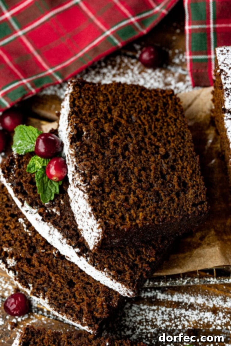 Classic Gingerbread Loaf 13 A captivating photo of several slices of gingerbread loaf stacked neatly, each piece delicately dusted with powdered sugar, creating an inviting presentation.