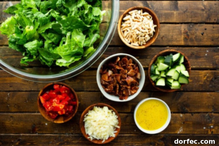 All the fresh ingredients for Salad de Maison, neatly arranged in separate bowls on a rustic wooden table, awaiting assembly.