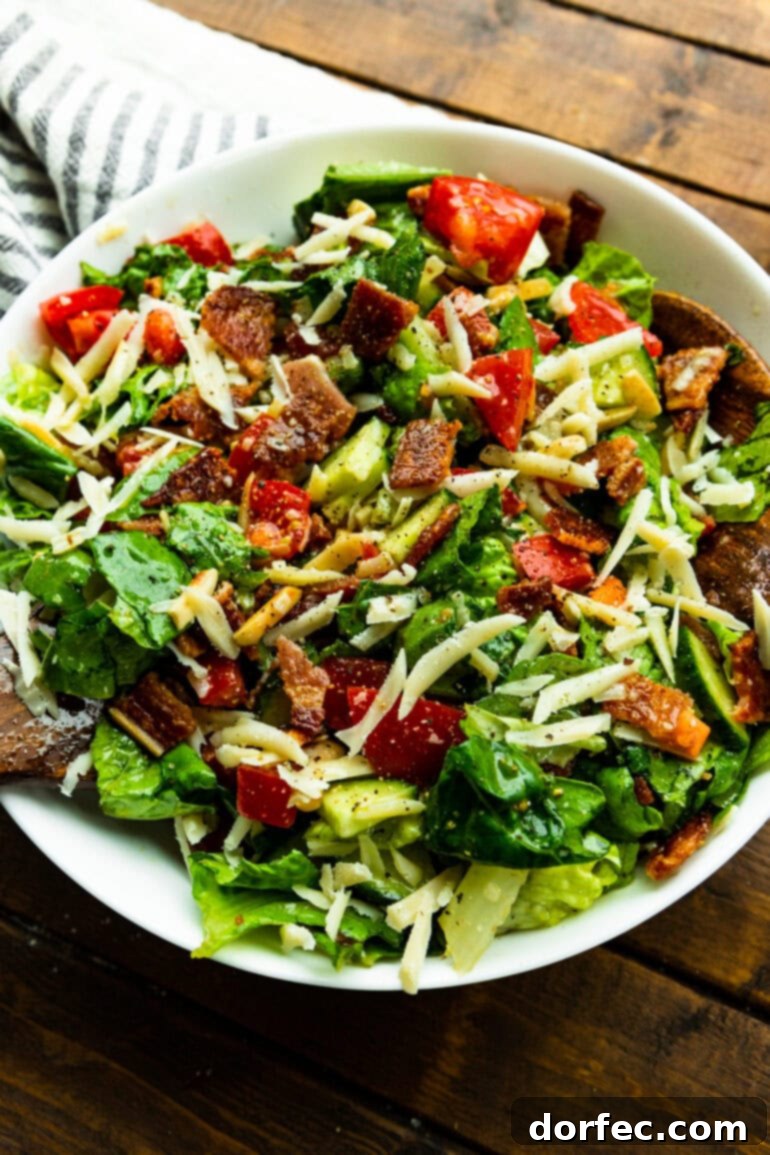 A tantalizing image of a perfectly tossed green salad, adorned with crunchy slivered almonds, rich Manchego cheese, and savory crispy bacon crumbles, showcasing its irresistible appeal.