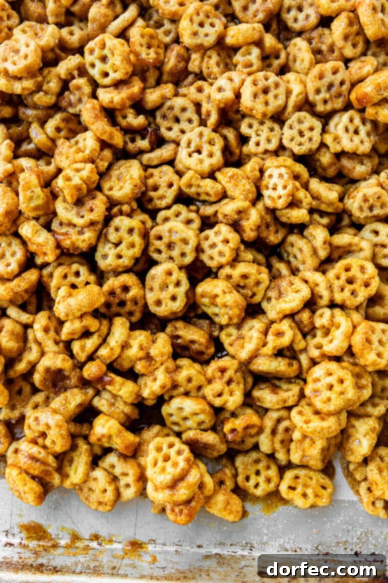 A baking sheet generously covered with freshly made, caramel and cinnamon sugar coated Honeycomb cereal, forming a delicious no-bake churro snack mix.