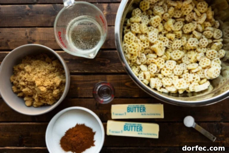 A flat lay photo showcasing all the simple ingredients for no-bake churro snack mix, including Honeycomb cereal, butter, brown sugar, cinnamon, and light corn syrup.