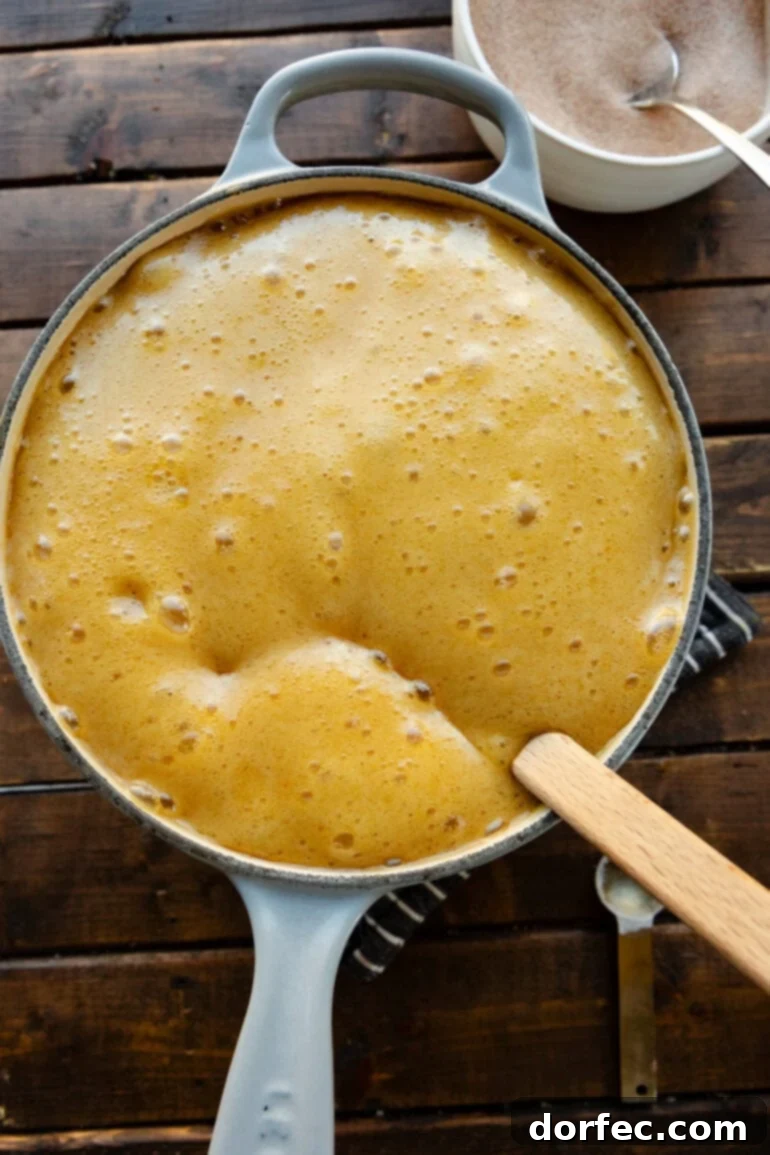 Step 1: Preparing a baking sheet with parchment paper and pouring Honeycomb cereal into a large bowl for the no-bake churro snack mix.