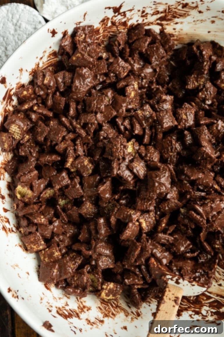 Melted chocolate mixture being poured over Chex cereal in a large bowl