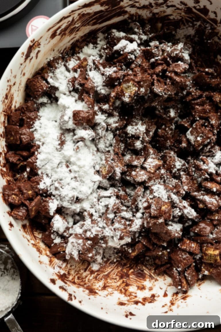 Powdered sugar being added to the chocolate-coated Chex cereal