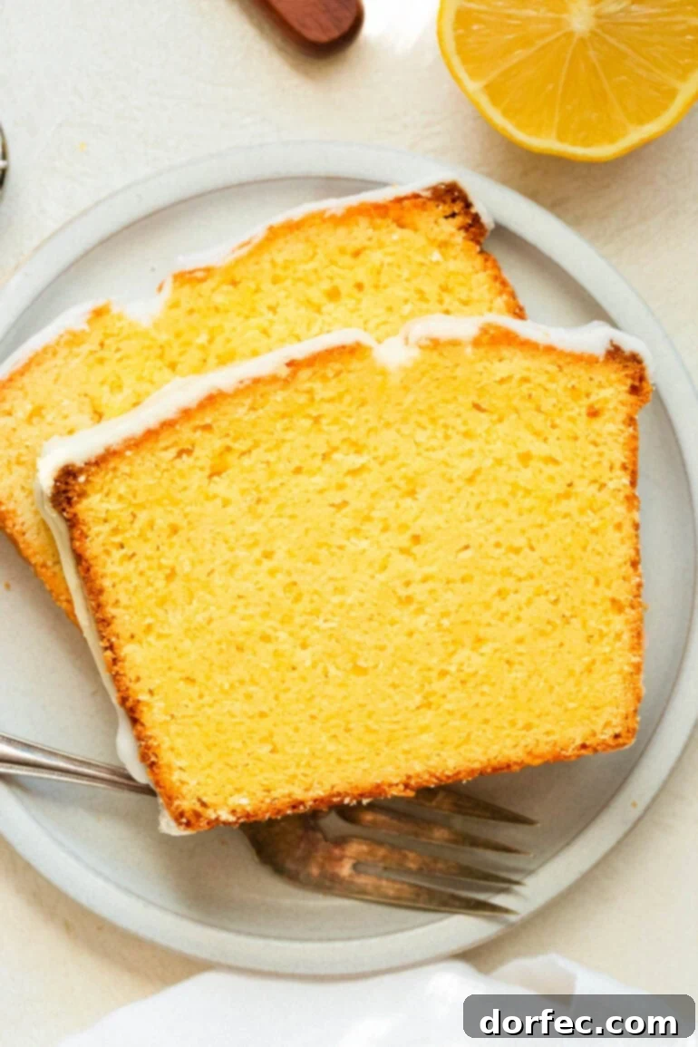 Zesty Lemon Glazed Loaf 2 Two exquisite slices of glazed lemon pound cake, perfectly plated on a small white dessert plate, ready to be enjoyed.