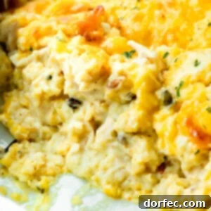 Super Creamy Cheesy Chicken and Rice Casserole 10 A photo of a chicken and rice casserole in a casserole dish with scoops of the casserole removed