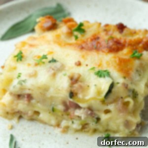 A photo of a serving of white vegetable lasagna being scooped out of a full pan, highlighting its creamy layers and golden crust.