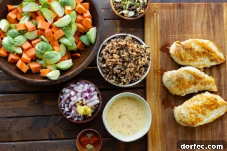 Wholesome Autumn Chicken Bake 4 A vibrant flat lay photo of all the individual ingredients for Healthy Harvest Chicken Casserole laid out in separate bowls, including sweet potatoes, Brussels sprouts, red onions, chicken breasts, and seasonings.