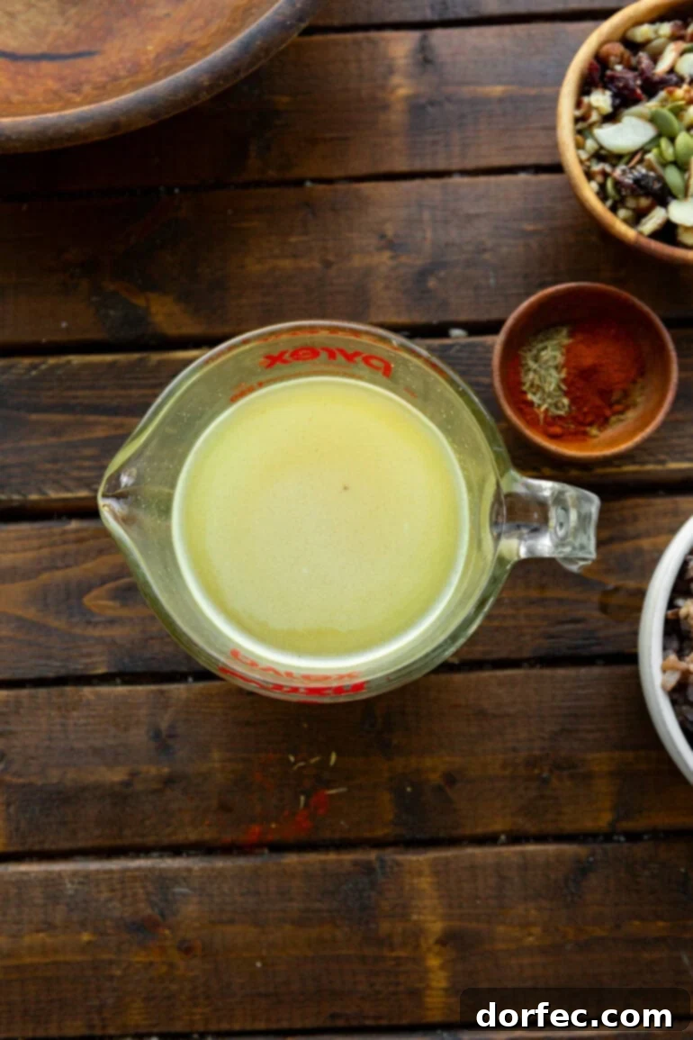 Wholesome Autumn Chicken Bake 5 A glass measuring cup filled with rich, creamy honey mustard dressing, a key component of the casserole's flavor.