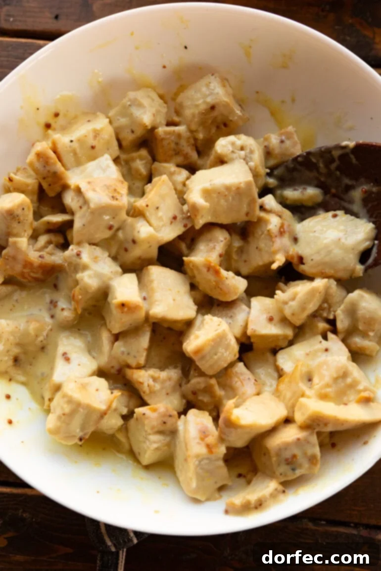 Wholesome Autumn Chicken Bake 6 A close-up of boneless, skinless chicken breast chunks cooking in a large skillet, browning beautifully.