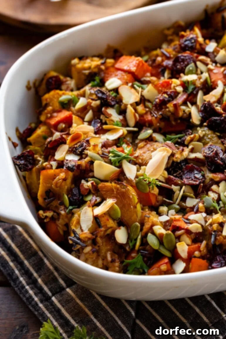Wholesome Autumn Chicken Bake 7 A large white baking dish filled with a rich and colorful harvest chicken casserole, featuring chicken, sweet potatoes, Brussels sprouts, red onion, and pepitas in a creamy sauce.