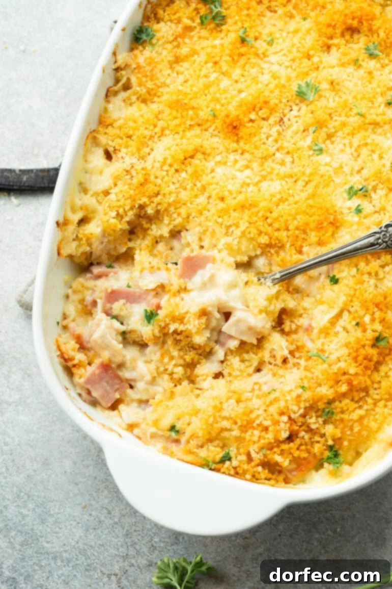 A baked Chicken Cordon Bleu Casserole with a serving spoon taking out a portion, ready to be enjoyed as an easy and flavorful dinner.