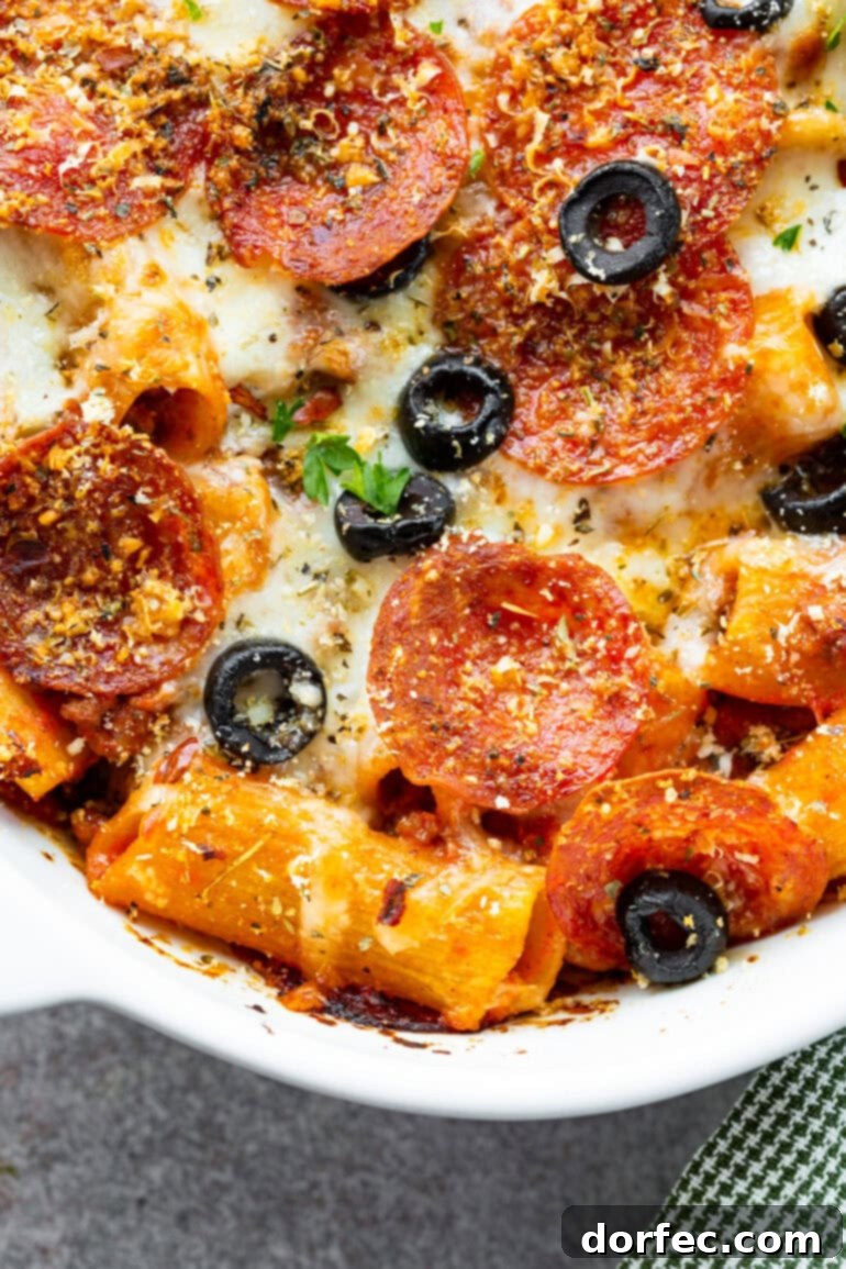 a photo of a casserole dish full of baked pizza casserole topped with sliced olives and melted mozzarella cheese
