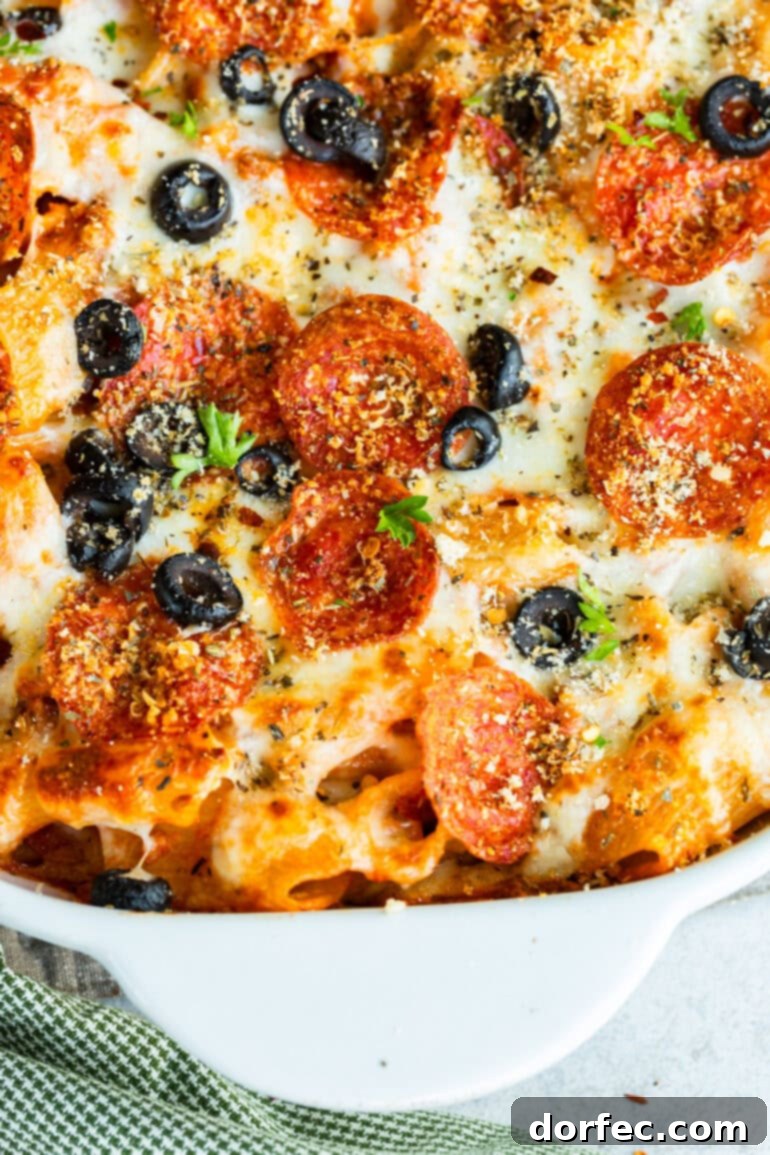 a photo of a baked pepperoni pizza casserole sprinkled with sliced olives and fresh herbs