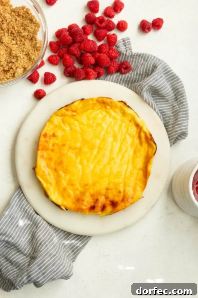 Creamy Baked Yogurt Cheesecake 4 A photo of a golden baked yogurt sitting on a white cutting board, ready for toppings.