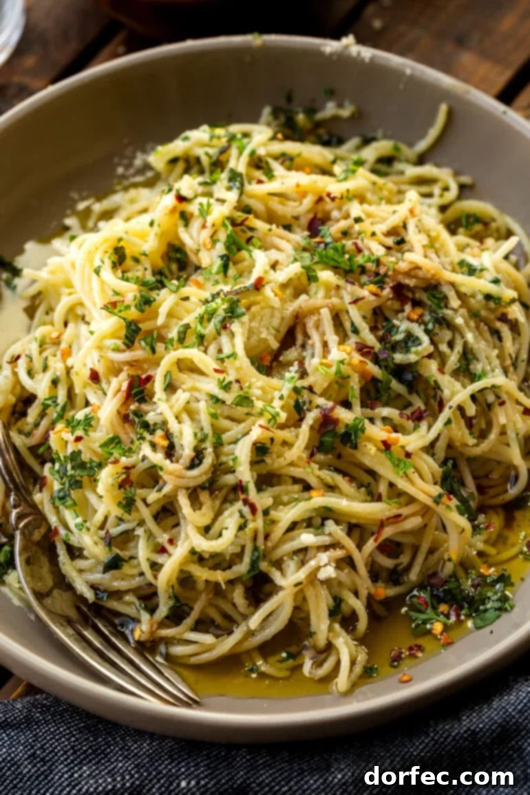 A close-up shot of spaghetti aglio e olio, showcasing the detailed texture of the pasta, green herbs, and red pepper flakes, with a hint of Parmesan.