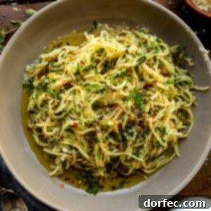 a photo of hot sizzling italian oil over fresh spaghetti and loaded with fresh herbs