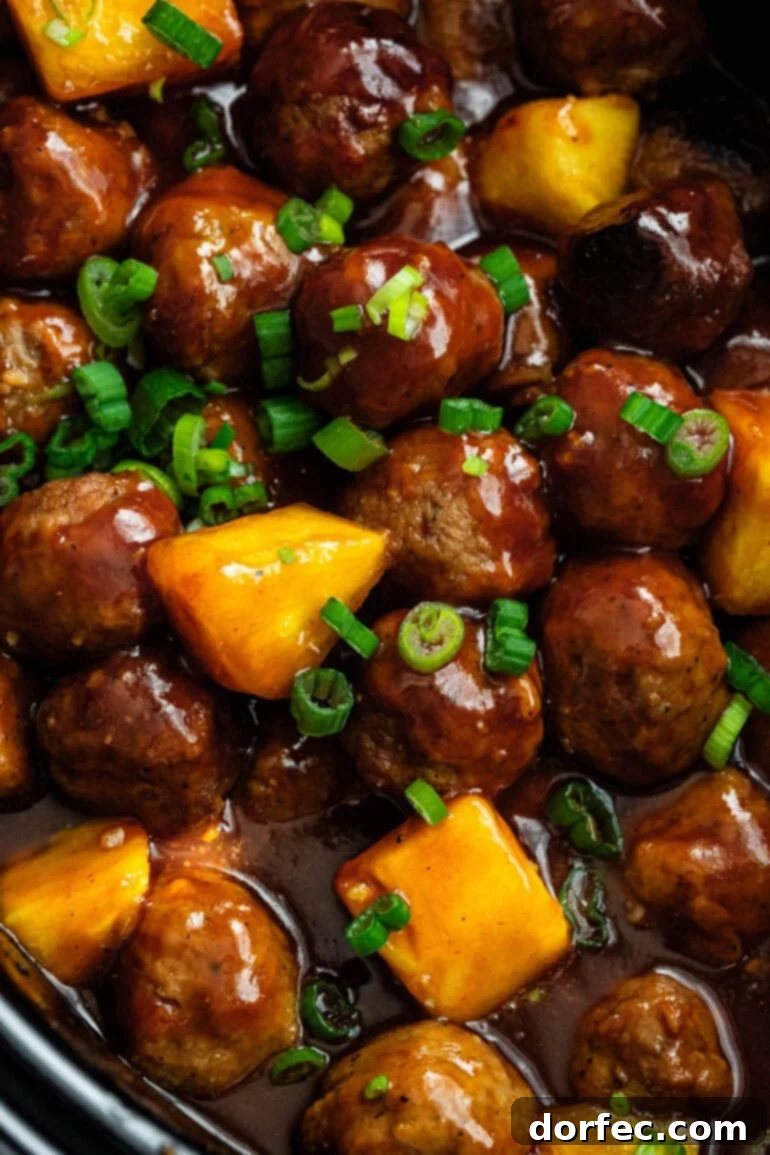 juicy saucy hawaiian meatballs mixed with chunks of pineapple and sprinkled with chopped green onions