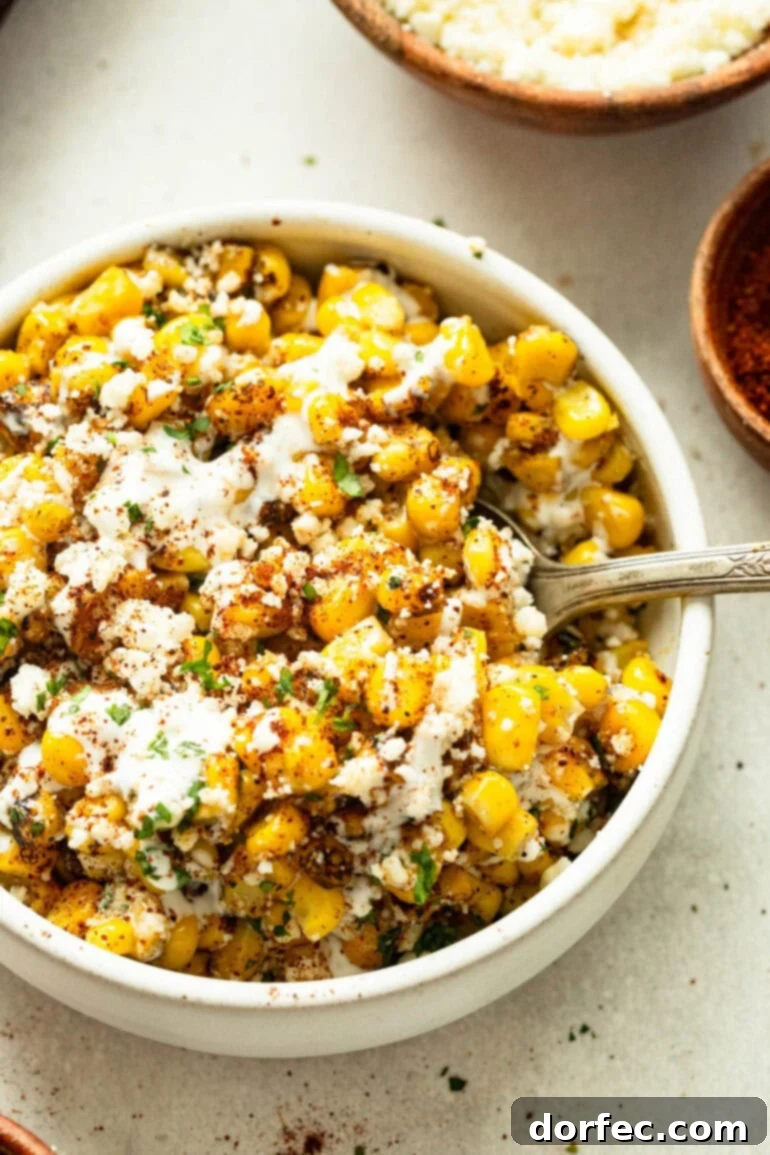 Sheet Pan Oven Elote 2 a photo of a white serving bowl full of roasted sheet pan mexican street corn topped with cotija cheese