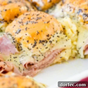 Delicious ham and cheese sliders with poppy seed dressing, ready to bake.