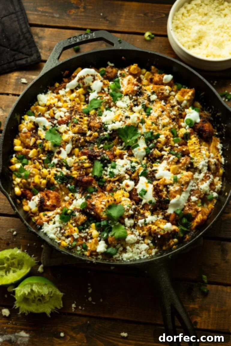 Creamy Mexican Street Corn Chicken Skillet 9 A cast iron skillet brimming with creamy Mexican street corn chicken, generously topped with crumbled cotija cheese, fresh cilantro, and green onions.