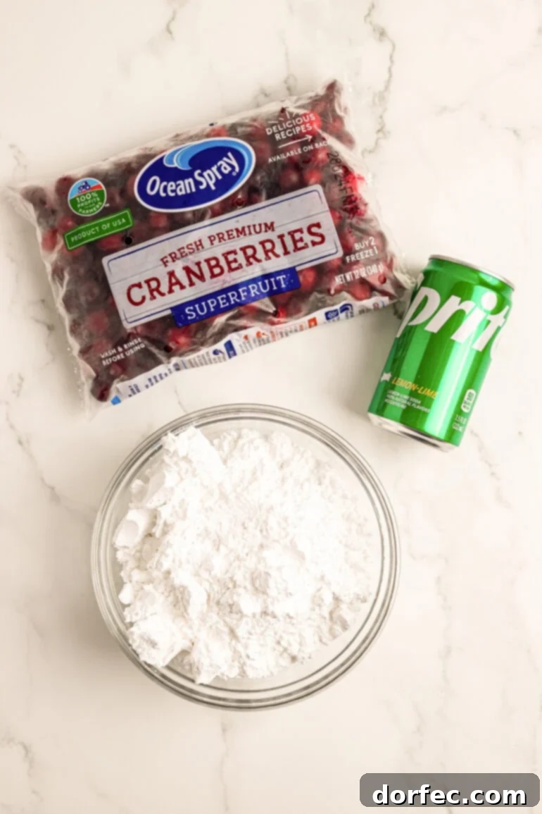 Glittering Sweet Tart Cranberries 3 A visual display of the three essential ingredients for making candied cranberries: a bag of fresh whole cranberries, a can of lemon-lime soda (Sprite), and a bowl of powdered sugar.