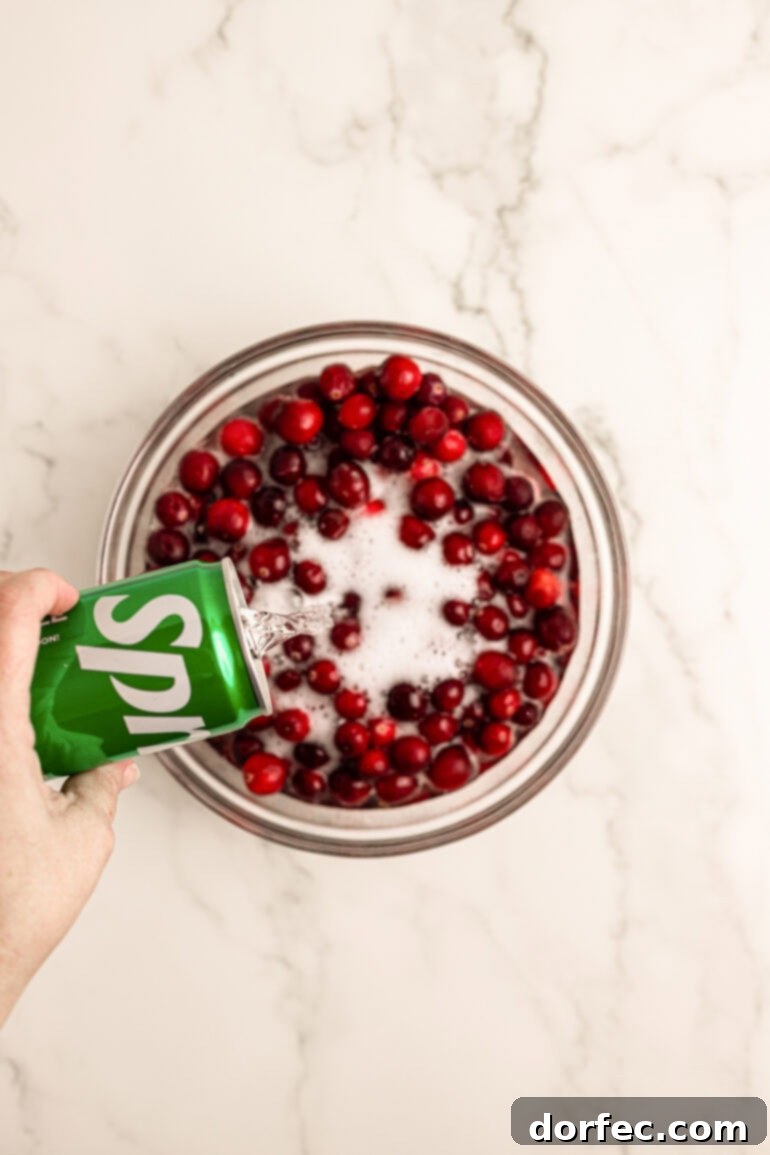 Glittering Sweet Tart Cranberries 5 Step-by-step image of cranberries soaking in lemon-lime soda.