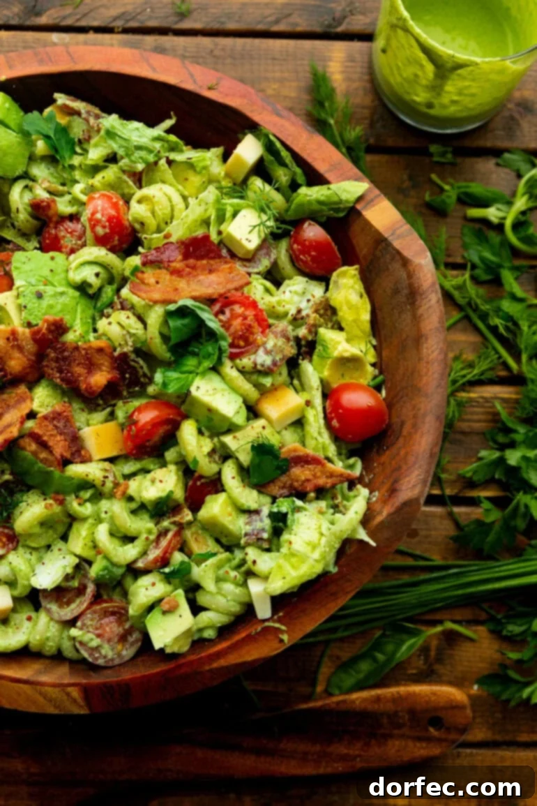 a photo of creamy blt pasta salad in a large wooden serving bowl