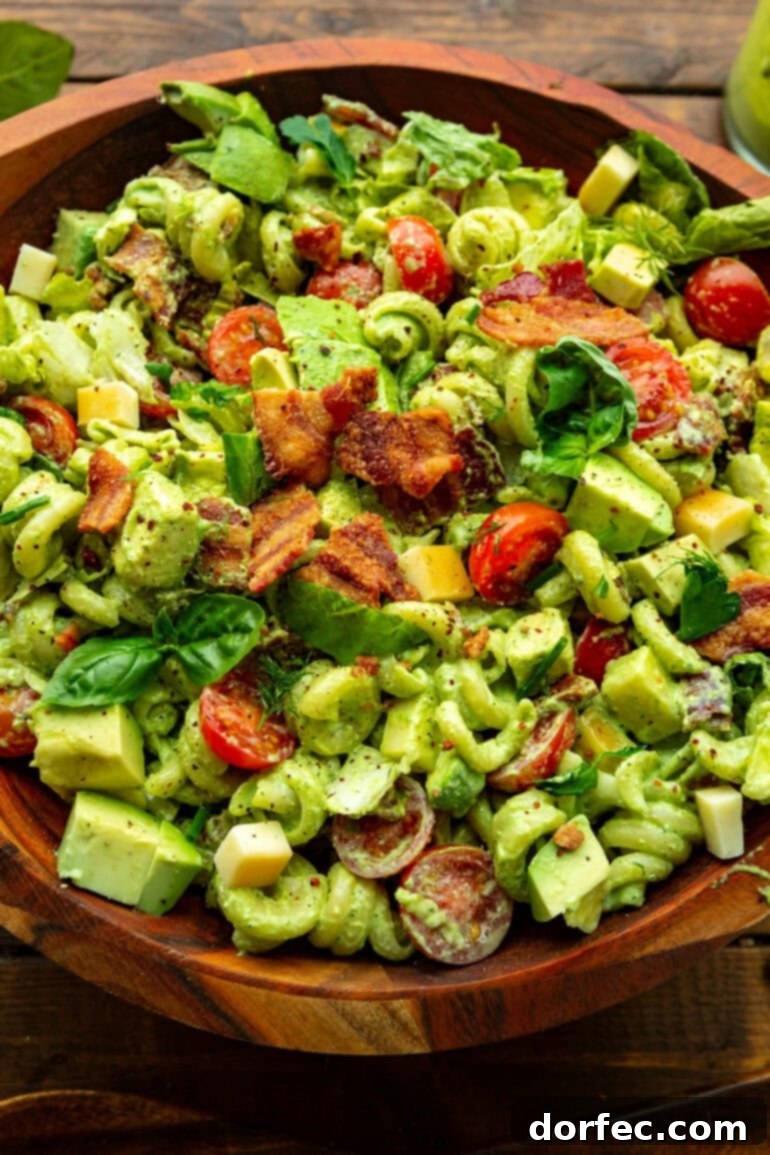 a photo of a creamy blt pasta salad in a wooden serving bowl