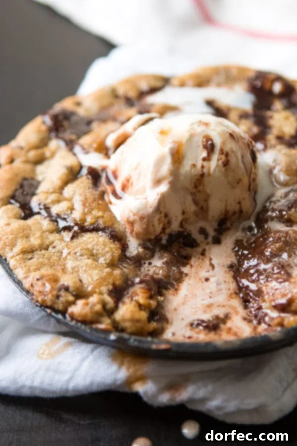 Delicious Millionaire Skookie Dessert Millionaire Skookie fresh out of the oven, topped with vanilla ice cream and sauces, ready to be enjoyed.