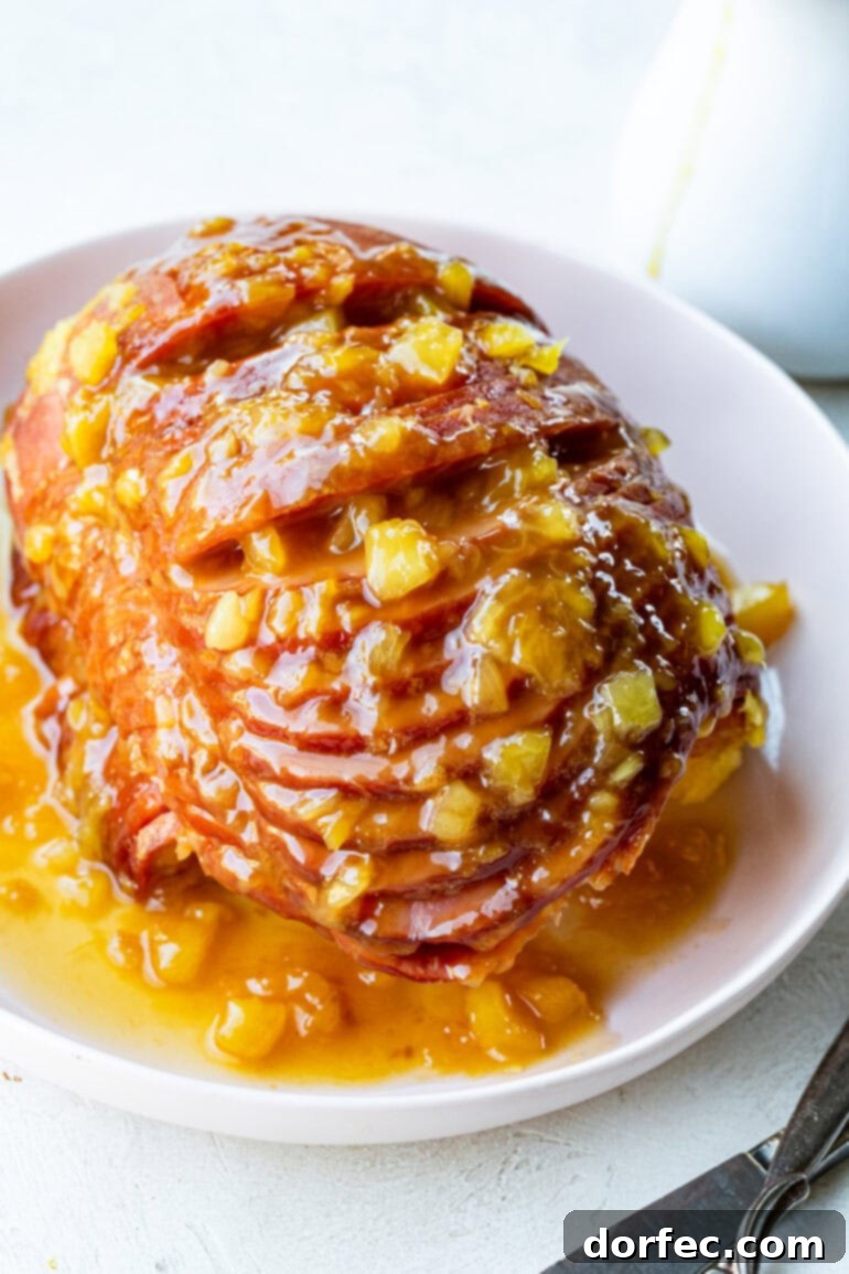 Perfectly Tender Slow Cooker Ham 7 A stunning photo of a whole spiral cut ham, elegantly presented on a serving platter, beautifully coated in a glistening, juicy pineapple glaze. It's ready to be the centerpiece of any meal.