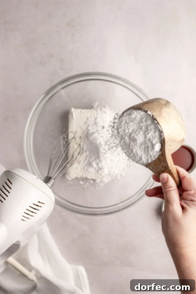 Fluffy Tangy Cream Cheese Frosting 5 Step 2: A separate bowl holding softened cream cheese, powdered sugar, salt, and vanilla extract, ready to be combined into a smooth base.