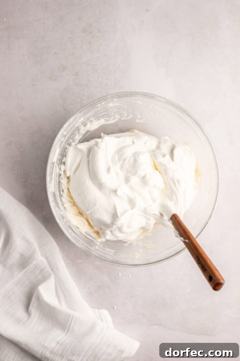 Fluffy Tangy Cream Cheese Frosting 9 Step 6: The finished, perfectly combined whipped cream cream cheese frosting, showcasing its light, smooth, and airy texture, ready for use.