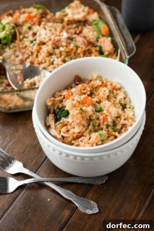 Enjoy takeout-style Teriyaki Chicken Casserole at home, packed with fried rice, chicken, and veggies! Teriyaki Chicken Casserole served in stacked white bowls, ready to be enjoyed. The rich colors of the chicken, rice, and vegetables are enticing, promising a delicious homemade meal reminiscent of takeout.