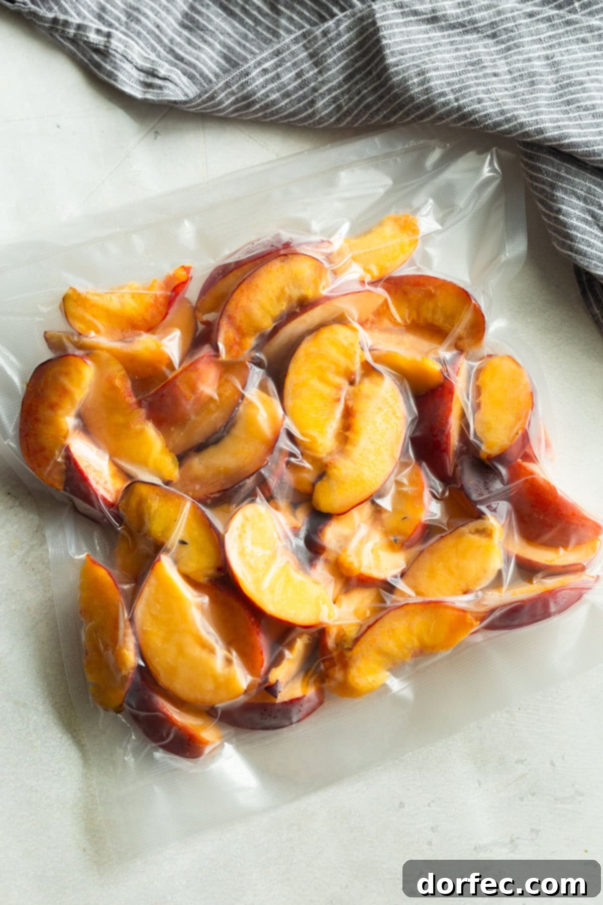 Vacuum-sealed freezer bag filled with sliced peaches, ready to be stored for long-term freezing.