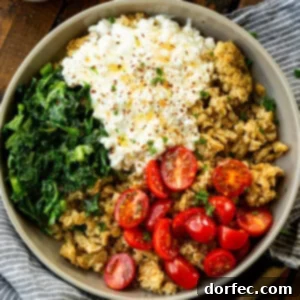 A bowl of crispy golden oats, cottage cheese, tomatoes and kale topped with seasonings
