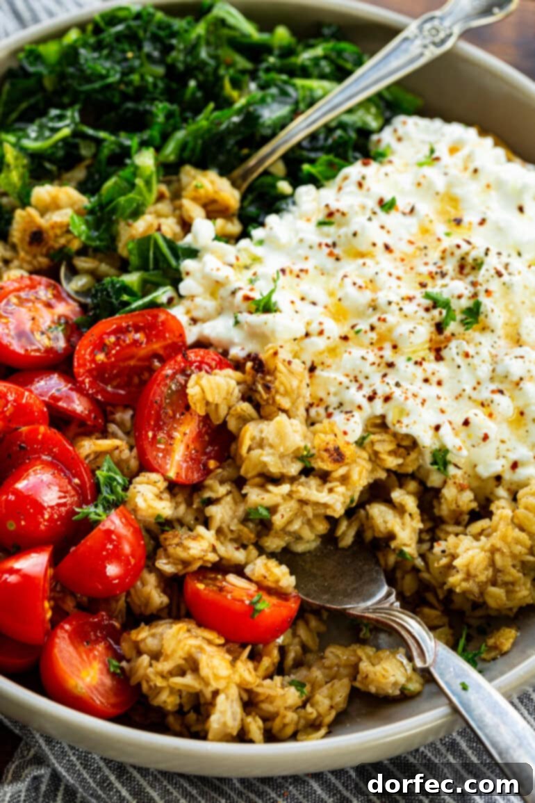 Speedy Savory Protein Oats with Cottage Cheese 3 A close-up shot of a savory oatmeal bowl featuring creamy cottage cheese, vibrant halved cherry tomatoes, and tender chopped kale, all seasoned to perfection.