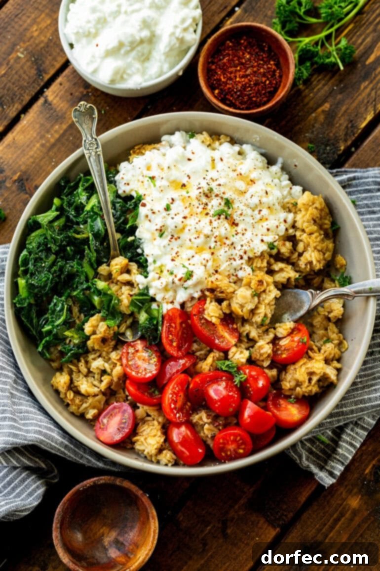 Speedy Savory Protein Oats with Cottage Cheese 5 A savory bowl of oatmeal with cottage cheese, cherry tomatoes, and chopped kale, with two forks invitingly placed, ready to be stirred and enjoyed.