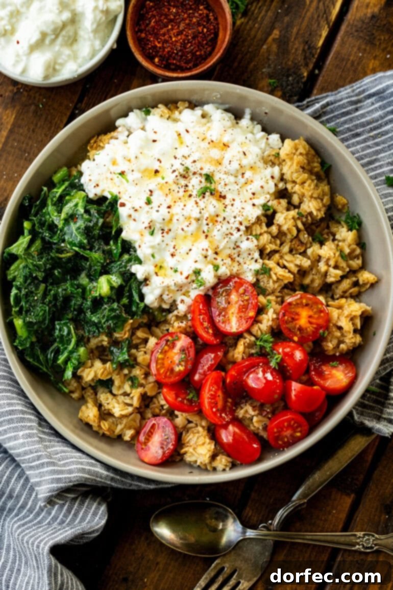 Speedy Savory Protein Oats with Cottage Cheese 10 A bowl filled with crispy golden savory oats, creamy cottage cheese, fresh tomatoes, and kale, beautifully topped with seasonings, inviting you to try this healthy breakfast option.