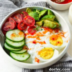 a photo of a large bowl full of cottage cheese, hard boiled eggs, sliced cucumber, cherry tomatoes and avocado topped with sweet chili sauce