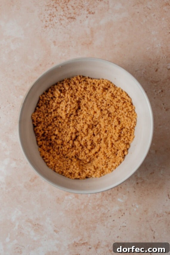 Combining graham cracker crumbs and sugar for the crust.