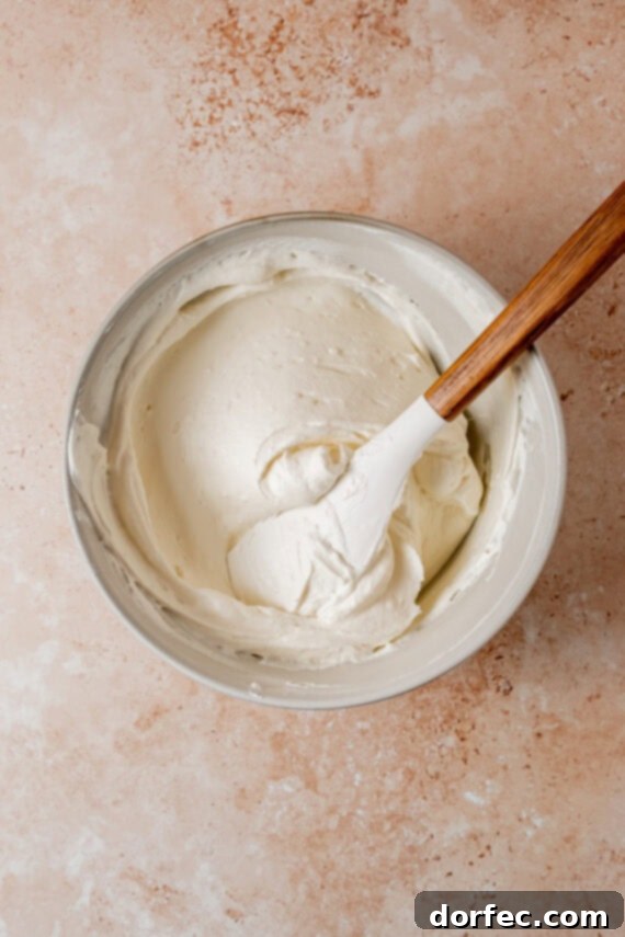 Mixing cream cheese, crème fraîche, and confectioners' sugar for the filling.