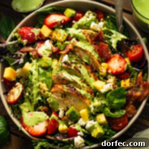 A salad with chicken, strawberries, and avocado