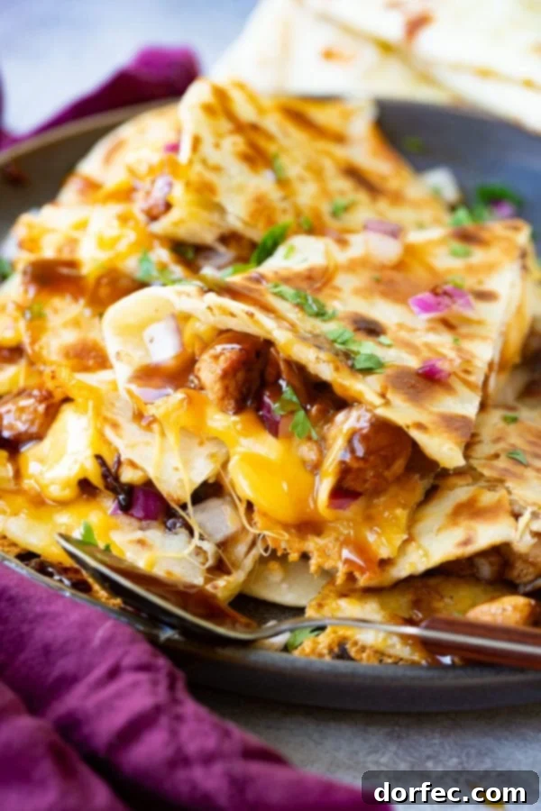 Teriyaki Chicken Quesadilla A photo of a slice of teriyaki chicken quesadilla garnished with minced red onion and chopped fresh cilantro.
