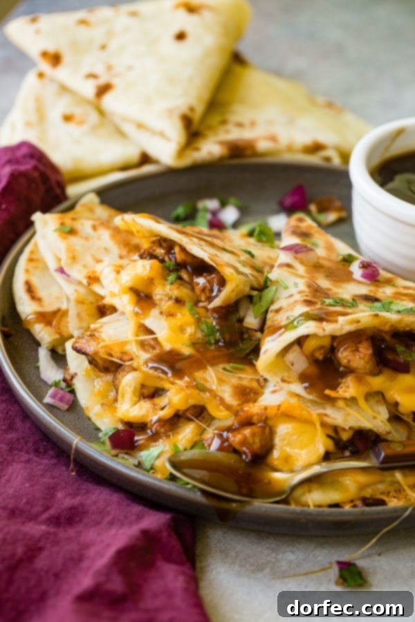 Teriyaki Chicken Quesadillas A photo of several slices of teriyaki chicken quesadilla garnished with minced red onion and chopped fresh cilantro.