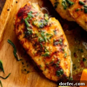 Grilled chicken breast on a wooden cutting board, topped with chopped fresh tarragon and a glossy citrus marinade.