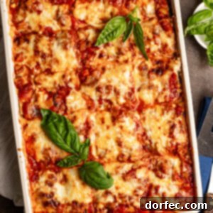 a pan of cheesy zucchini lasagna with fresh basil leaves on top