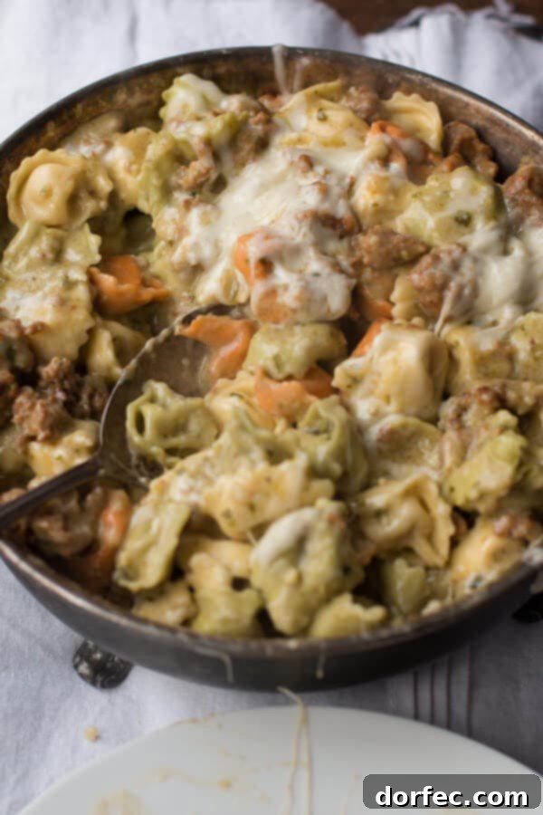 Low-Calorie Pesto Pasta Recipe Detailed shot of creamy pesto tortellini with mozzarella melting on top.