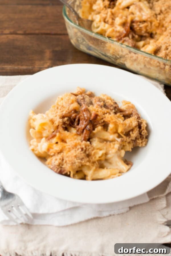 Serving of Sweet Pork Macaroni and Cheese garnished with fresh herbs